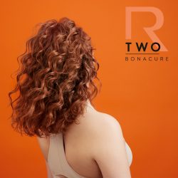 Schwarzkopf Bonacure R-TWO model with copper hair on orange background