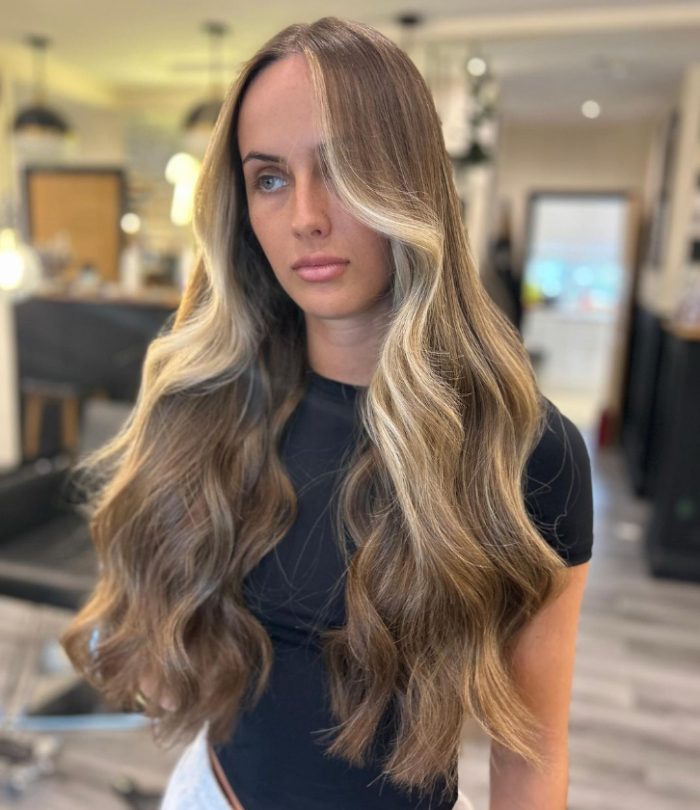 Long blonde hair with a light blonde face-framing highlight by @jakenugent.hair