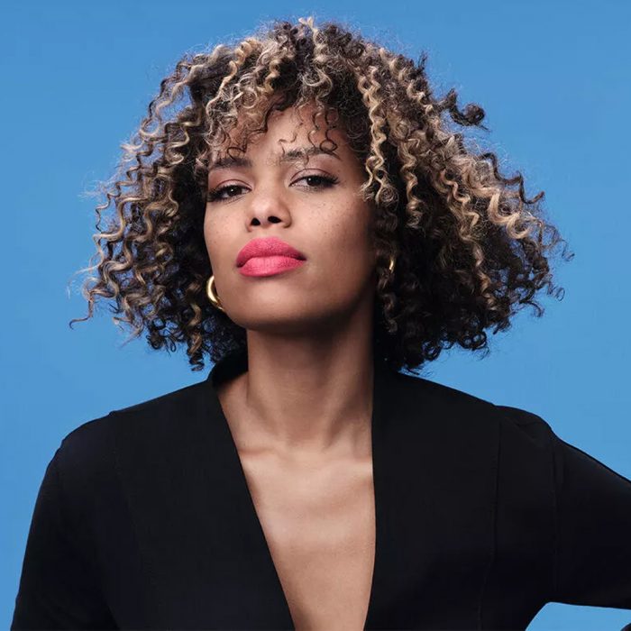 Wella express chunky highlights colour blocking model with short curly brown and blonde hair on a blue background