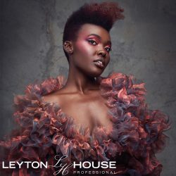 Leyton House Professional model wearing an orange ruffled dress on a dark grey marble background