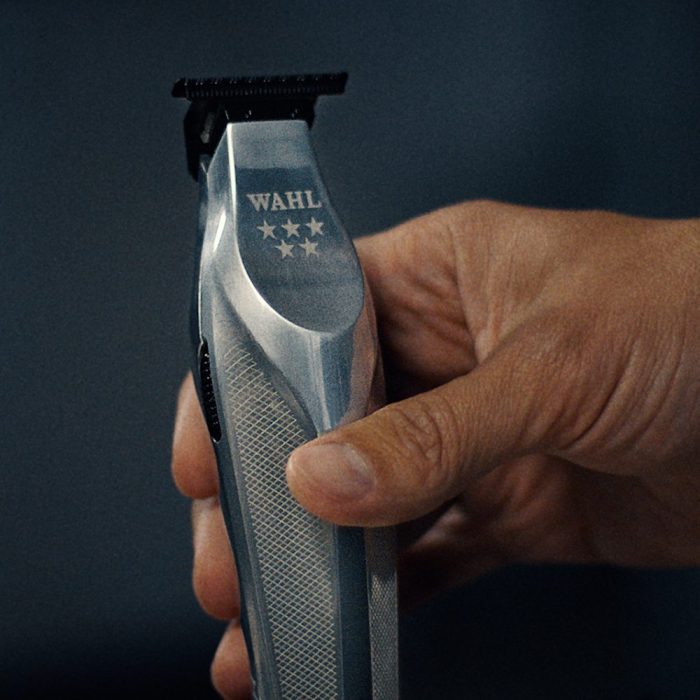 Wahl Hi-Viz Cordless Trimmer in hand against a dark blue background
