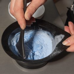 Bleach and developer being mixed in a hairdressing tint bowl