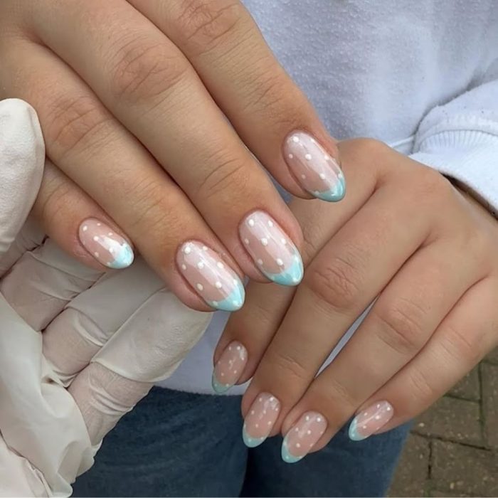 blue french nails with white polka dots finished with chrome