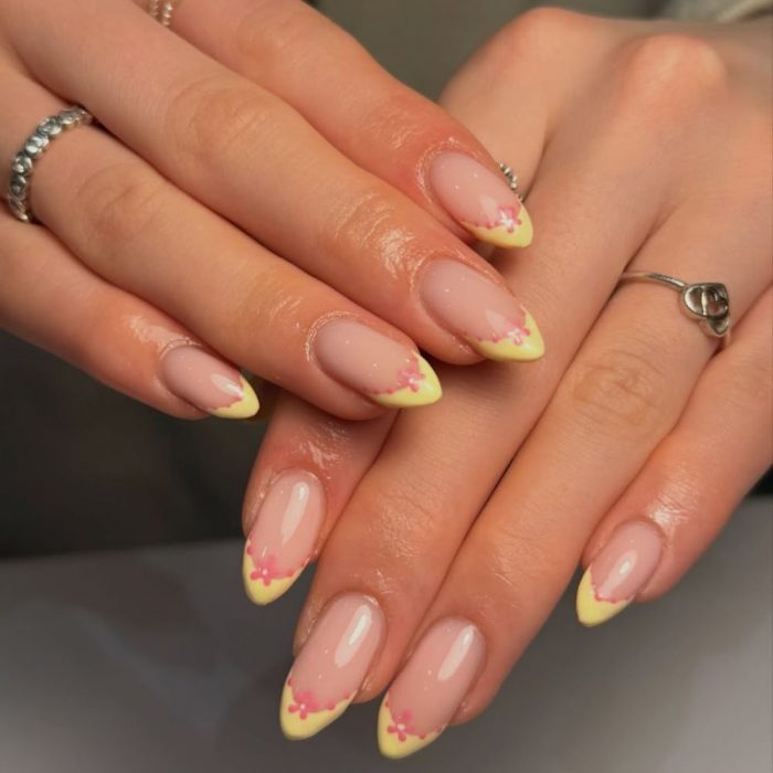yellow tips on nails with a pink flower