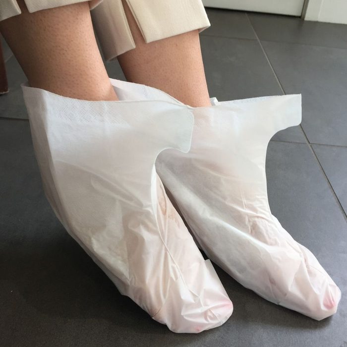 Foot mask boots on feet during pedicure treatment